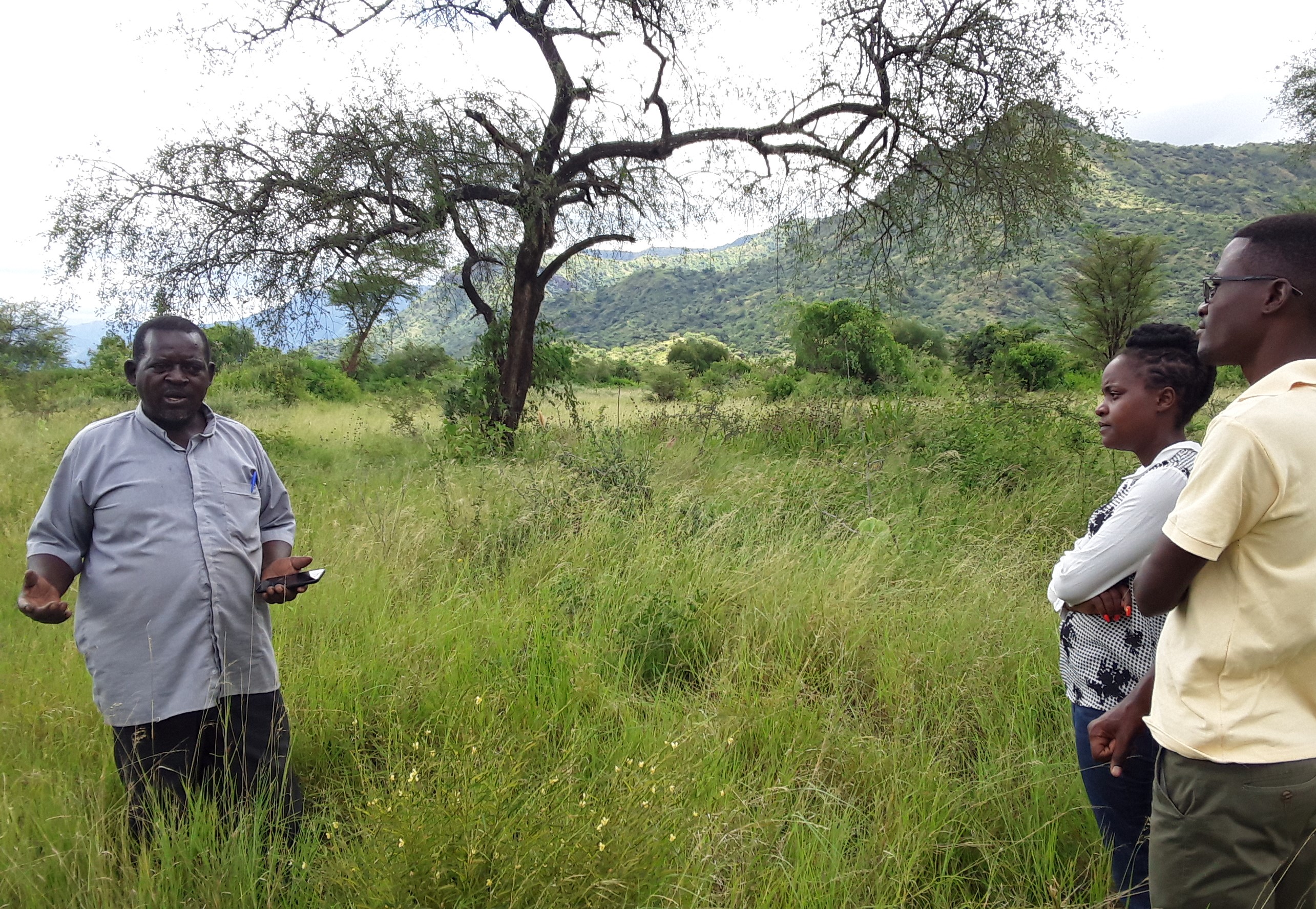Father Victor Mwekwasize zeigt dem Cross-Border Peace-Team die gute Bodenfruchtbarkeit ‎des Landes und die heimischen Pflanzen. ‎