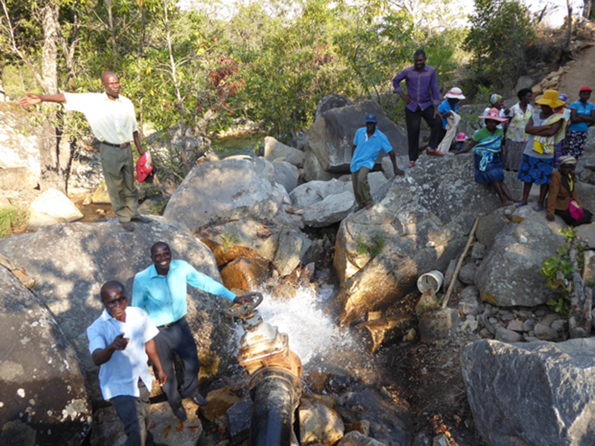 Test eines Ablassrohres durch ein Stauwehr zu Bewässerungszwecken, beteiligt ist die Partnerorganisation Caritas Masvingo in Zimbabwe.