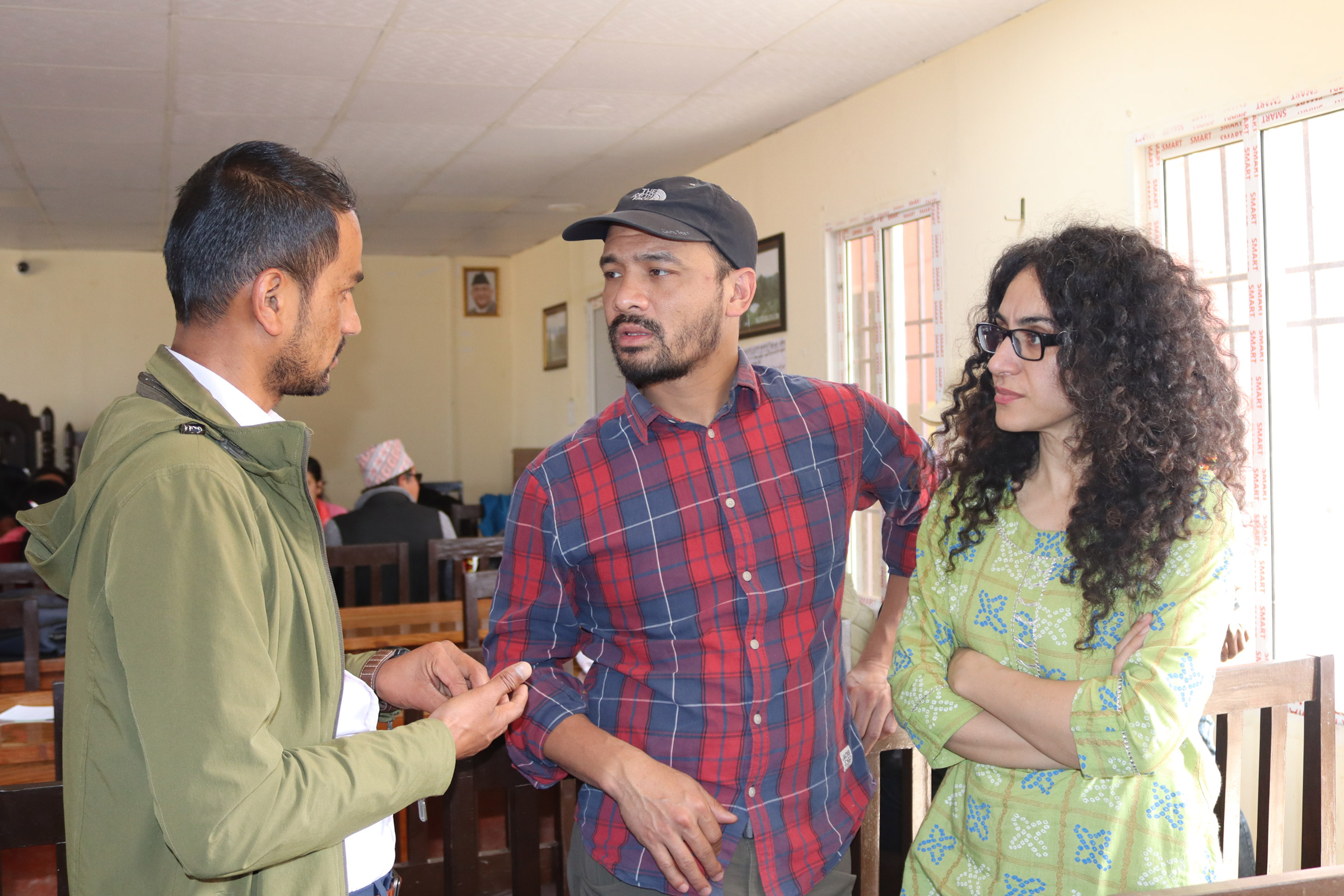 Hakimeh Yagootkar und Abishek Thapa sprechen mit dem Bildungsreferenten der ländlichen Gemeinde.