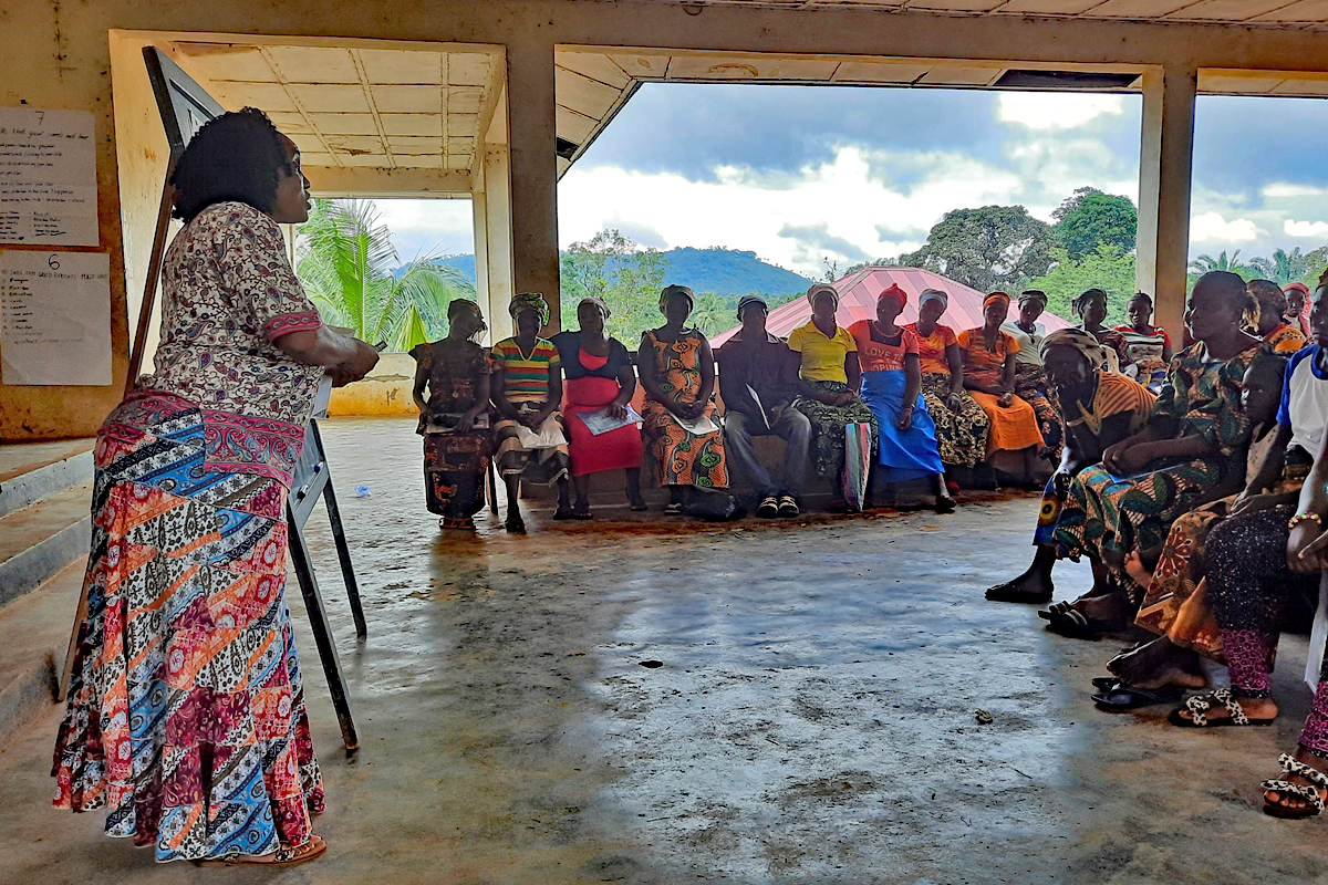 Laura Lahei (vorne) ist Projektmanagerin bei WAVES. Sie spricht vor einer Frauengruppe über sexualisierte Gewalt, zu der FGM gehört.