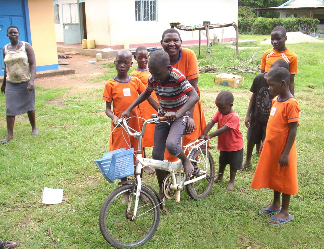Bei der Eröffnungsfeier des Internats freuen sich die Kinder über ein Fahrrad.
