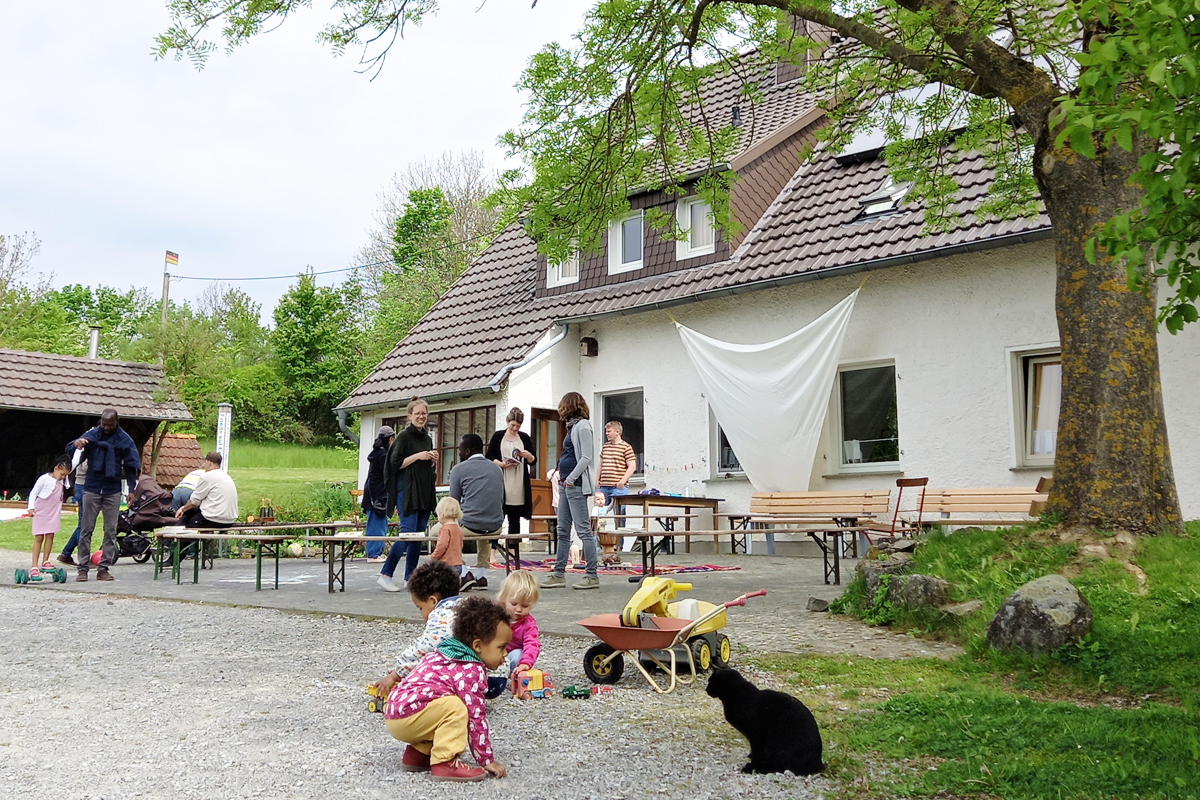Kurz vor der Abreise: die Kinder spielen vor dem Landhaus, die Erwachsene verabschieden sich.