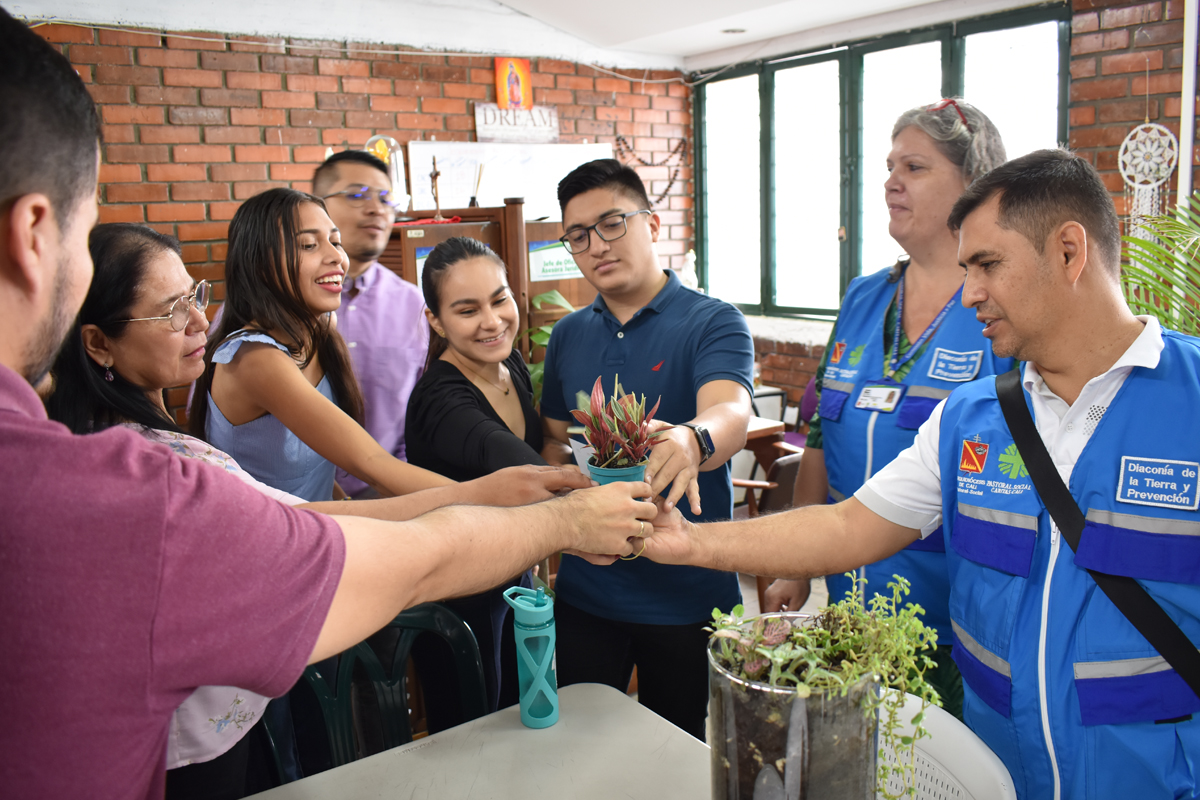 Im Rahmen der Aktionswoche "Laudato si" überreichen Claudia Witgens und ihr Kollege Mardoqueo Quevedo (rechts) den Juristen der Sozialpastoral eine Pflanze als Symbol für ihr Büro.