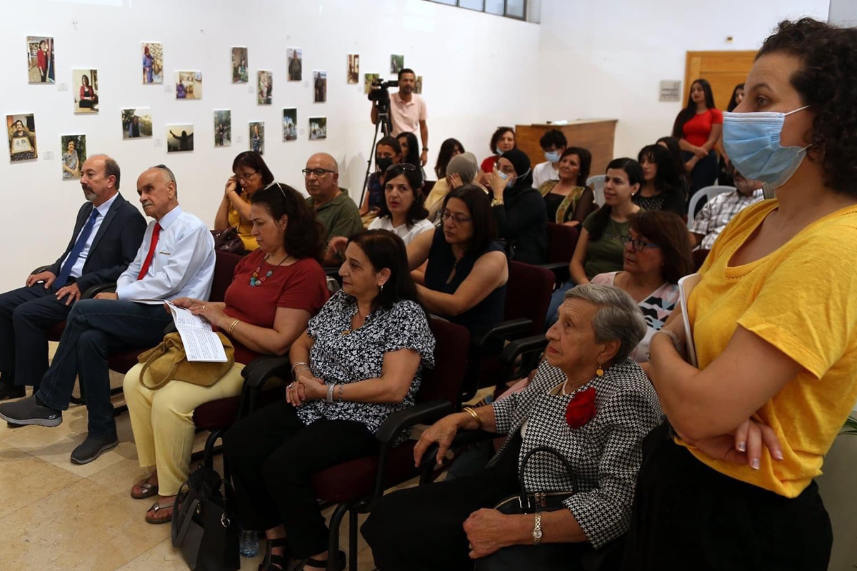 Besucher*innen hören auf der Abschlussveranstaltung eines Kunsttherapieprojektes einer Teilnehmerin zu. Mit Storytelling und einer Fotoausstellung ging es darum, Frauen sichtbarer zu machen.