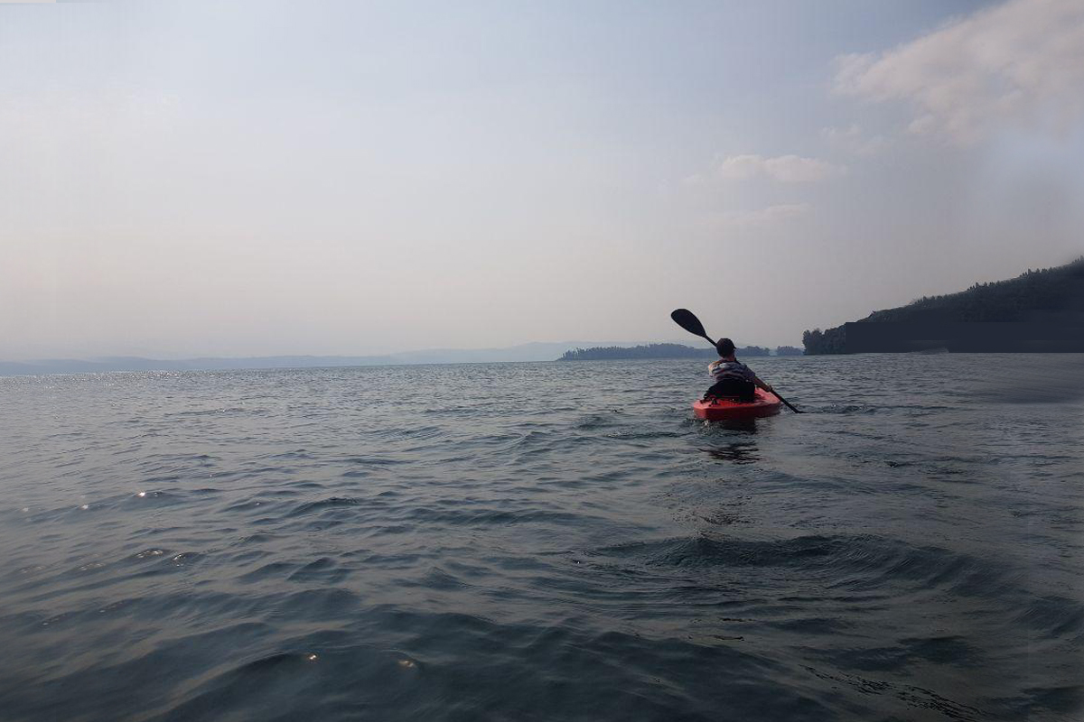 Ruth Ndashimye erholt sich beim Kajakfahren auf dem See in Rusizi. Die schöne Landschaft Ruandas lädt dazu ein, draußen aktiv zu sein. Aufgrund der guten Sicherheitslage ist Radfahren und Outdoor-Sport gut möglich.