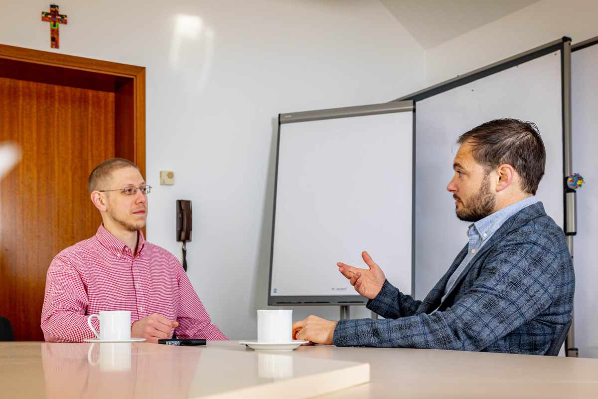 Jakob Königshof und Florian Schöpperle diskutieren in einem der Seminarräume von AGIAMONDO über eine genaue Definition von Friedenspädagogik. Die meisten friedenspädagogischen Projekte werden derzeit von Partnerorganisationen in Timor Leste und Jordanien durchgeführt.