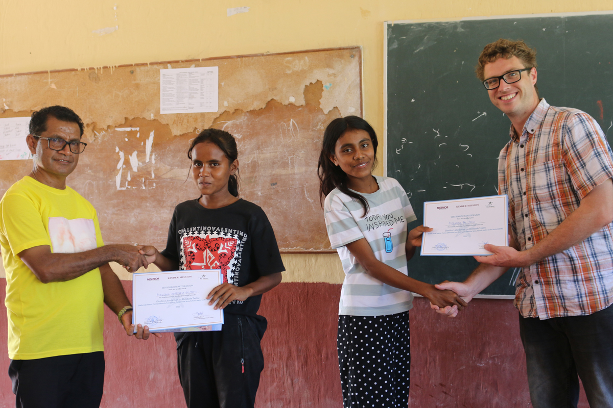 André de la Chaux überreicht zusammen mit einem Gemeindepfarrer Certifikate an jugendliche Teilnehmerinnen.