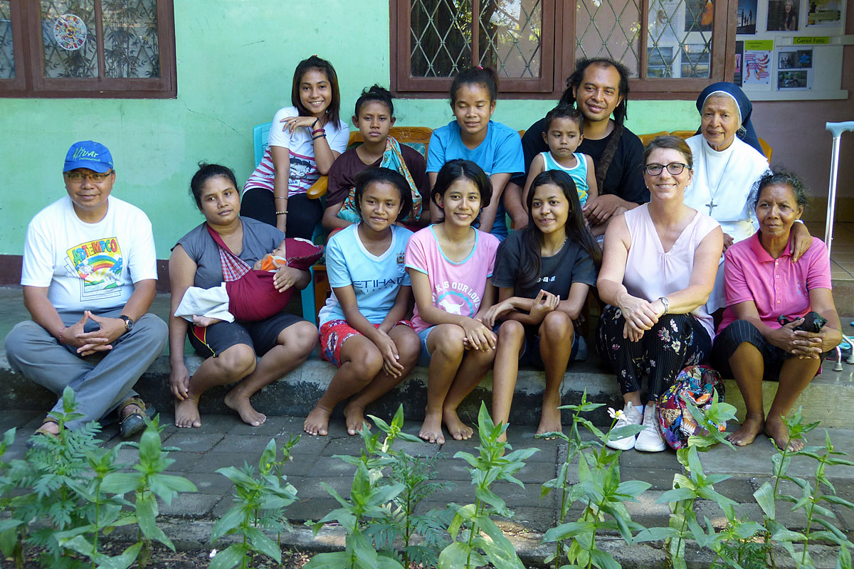 Die Fundraiserin der Steyler Mission, Alexandra Winand (erste Reihe, zweite von rechts), besucht das Projekt. Die Frauen bei TRUK-F machen auf die Diskriminierung und Gewalt gegen ihr Geschlecht aufmerksam.