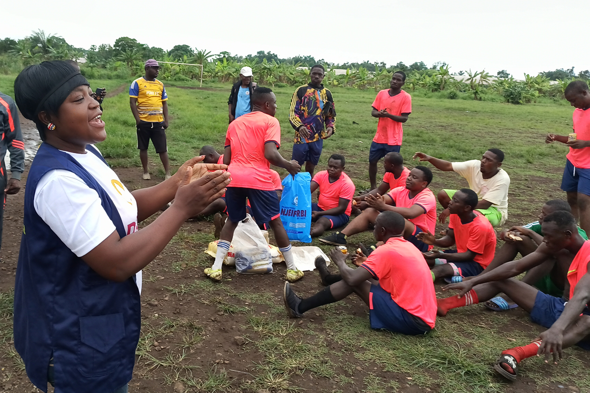 Charlotte Bih (links), Mitarbeiterin bei IYEC, sensibilisiert Jugendliche bei einem Fußballspiel zum Thema Drogen und Gewalt.