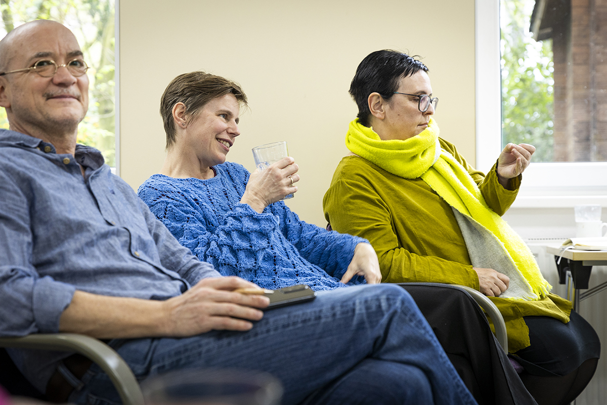 Thomas P., Iris Karanja und Monika Faes hören im Plenum der Einführung des Themas zu. Iris Karanja ist in der Vorbereitung zur ZFD-Koordinatorin in Kenia und Monika Faes übernimmt eine Stelle als Jugendkoordinatorin in Israel.