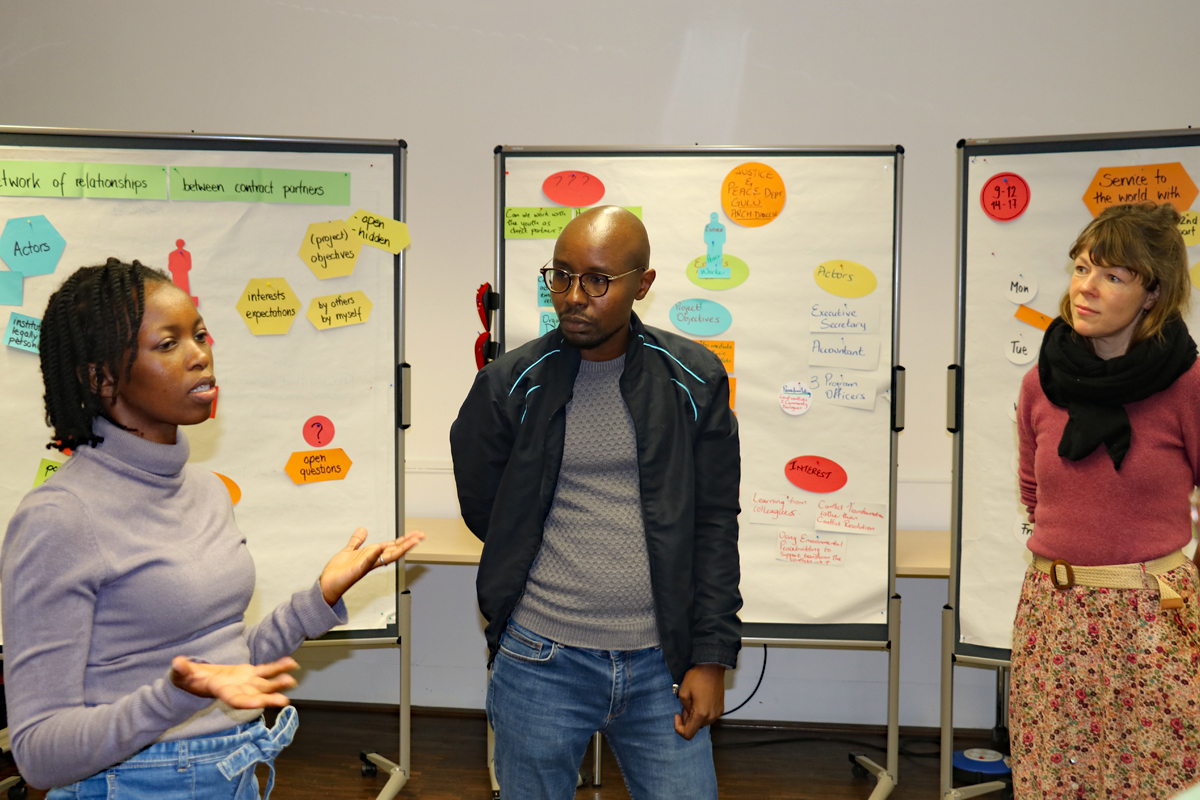 Esther Maina wird als Trainerin für Friedensarbeit nach Gulu/Uganda gehen und schildert die Anforderungen, die sie im Rahmen der Stelle sieht. Benjamin Kyeva und Eva Tempelmann hören zu (von links).