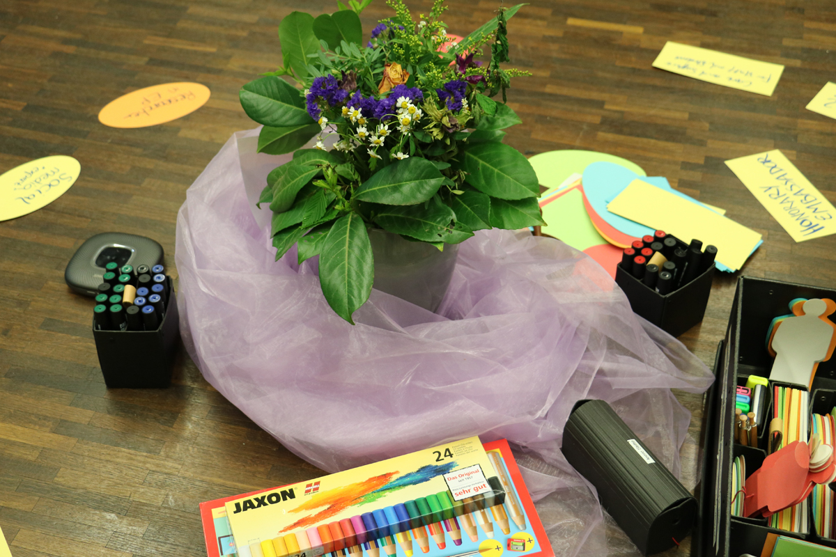 In der Mitte des Seminarraumes liegen Materialien bereit, um Ideen und Gedanken mit Worten oder Bildern festzuhalten.