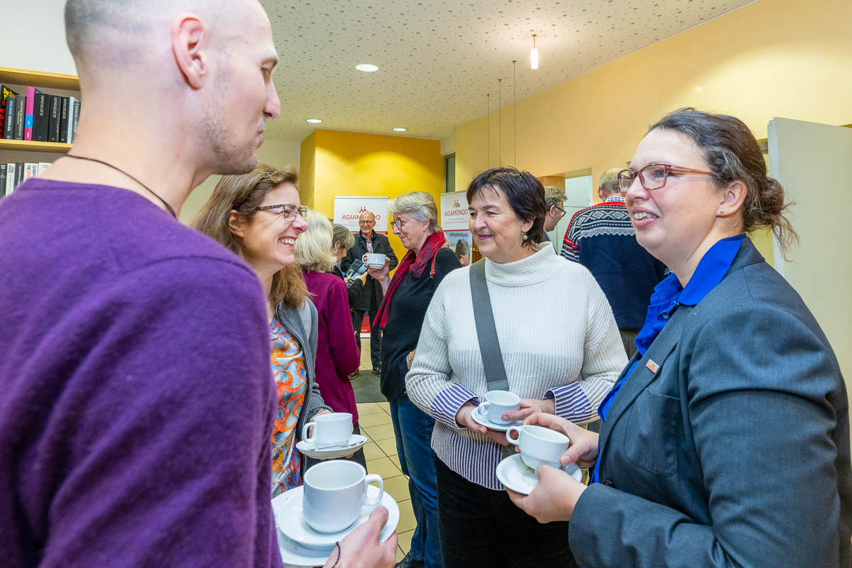 Menschen stehen in Gruppen zusammen im Gespräch