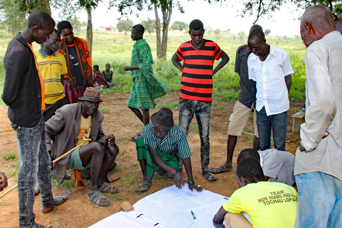 Gemeinschaft der Narisae studieren Landkarte Gruppe von Männern studiert Karte und spricht über Landeigentum der Gemeinschaft