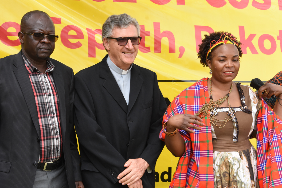 VertreterInnen des Land Desk Moroto 2 Männer und eine Frau auf einer Bühne