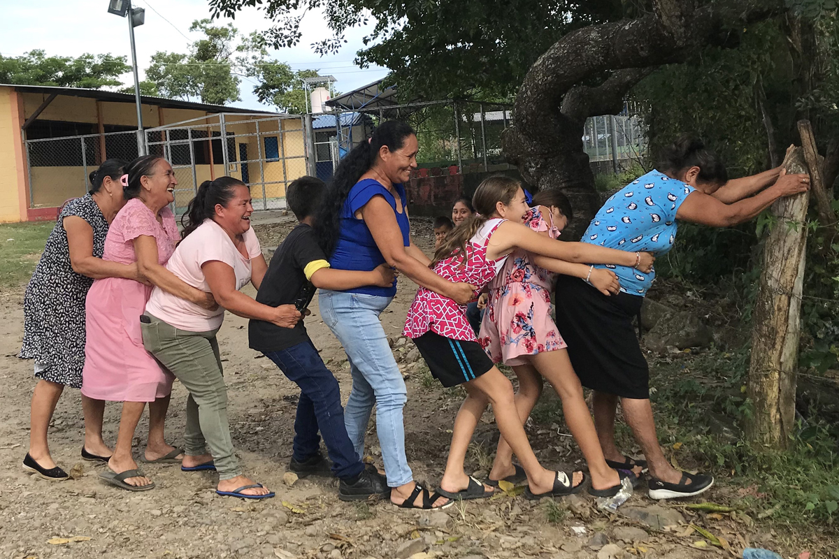 Großeltern, Eltern und Kinder spielen Kinderspiele von früher nach
