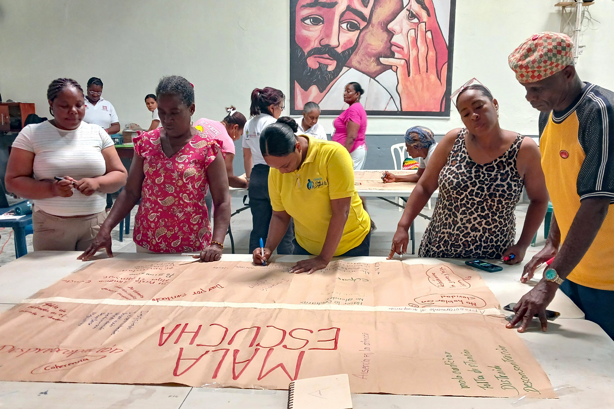 Gespräche und Arbeiten am Thema Aktives Zuhören eine Gruppe von Männern und Frauen schreibt auf große Papierbahnen