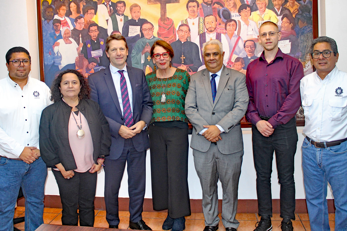 Menschengruppe vor großem Gemälde stehend.